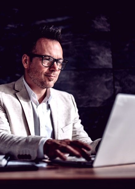 professional man in glasses using computer